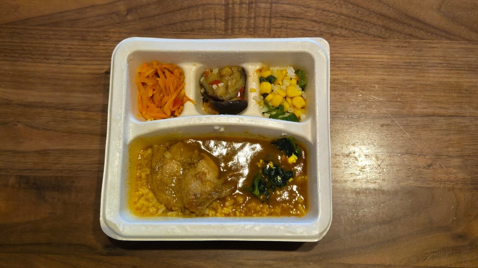 ナッシュ「バターチキンカレー」を開封し、上から撮影した全体像。副菜の彩りが分かる構図。