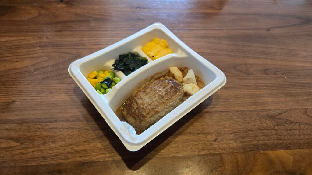 ナッシュのオニオングリルハンバーグを斜め上から撮影した写真。副菜とともにバランスよく配置されている。