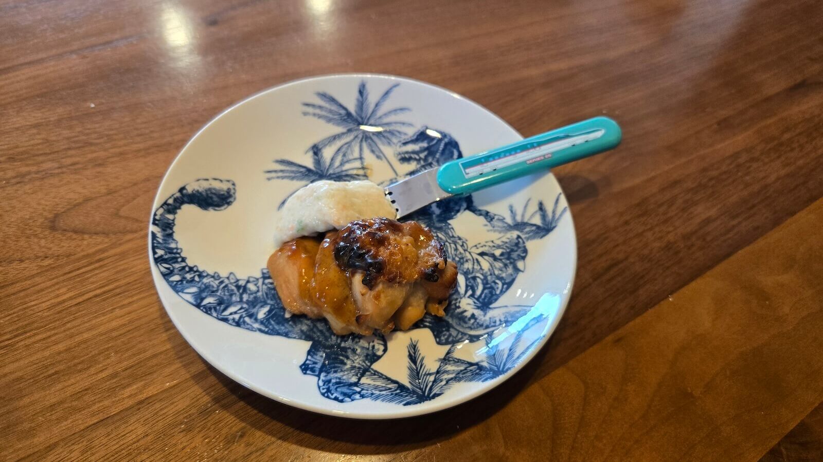 恐竜柄の子ども用皿と新幹線フォークで盛りつけたナッシュの照り焼き