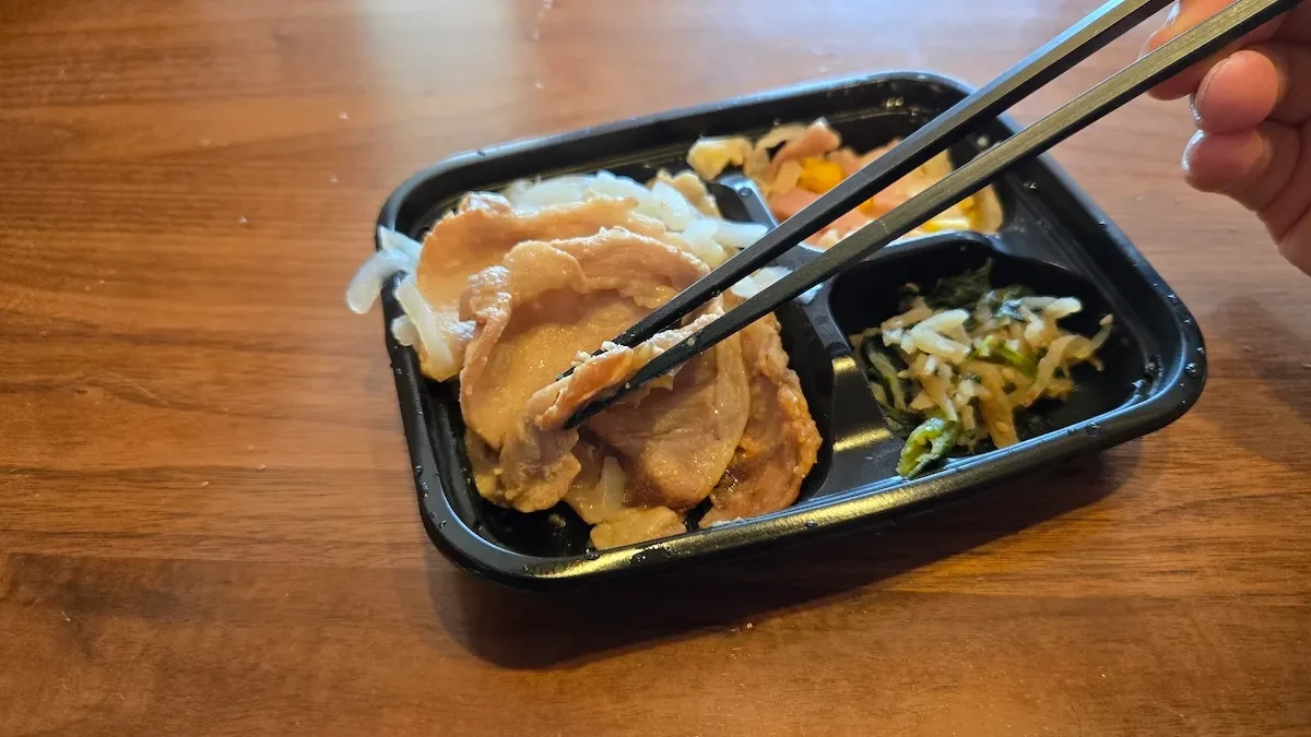 豚の生姜焼きを箸で持ち上げるシーン