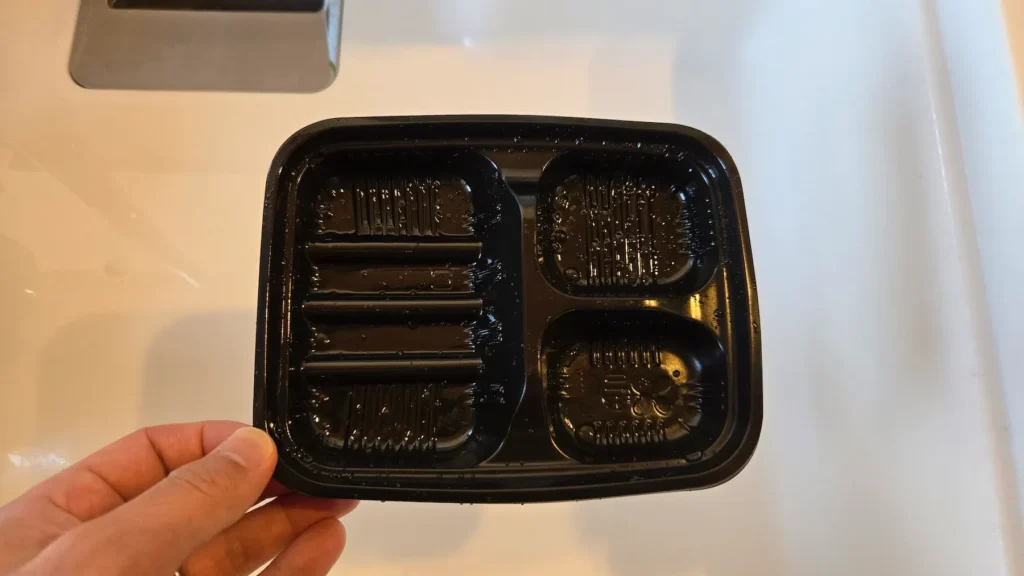 食後の空の黒いトレー(ワタミの宅食用容器)、軽く洗った状態