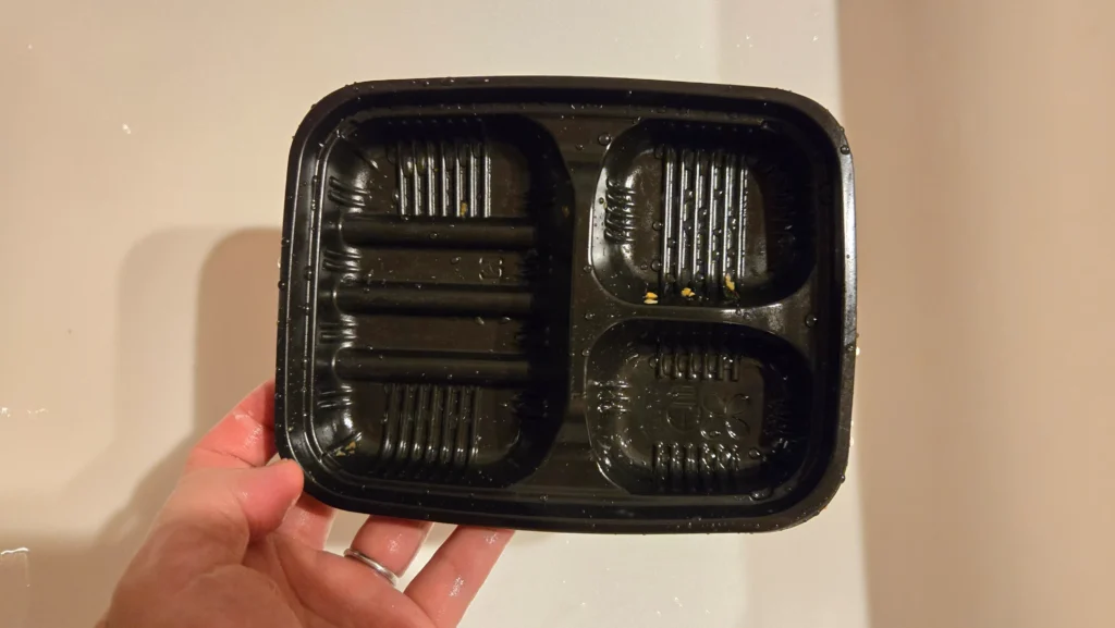 食べ終わった後の空の弁当トレー（黒い容器）